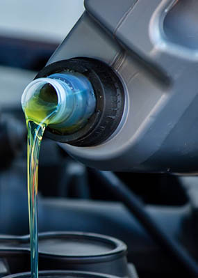 Amsoil Synthetic Oil being poured into a car's engine