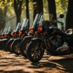 A line of motorcycles sitting in front of some trees